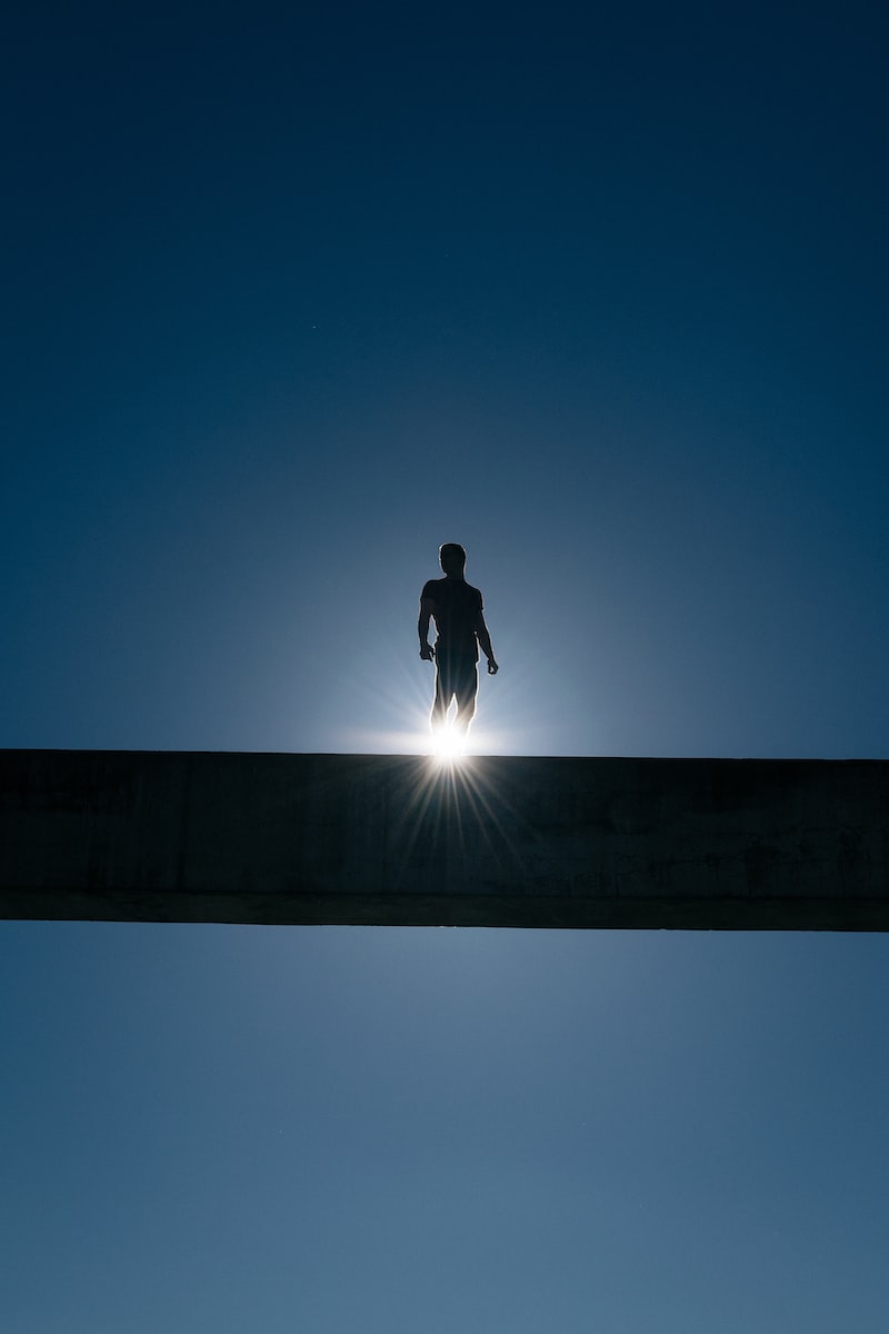 silhouette of man standing on bridge